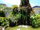 Lush, tropical landscaping surrounds a tiered rock waterfall feature in the community at 1935 Conway Rd # M1, Orlando, FL 32812