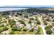 Aerial view captures a residential community near a scenic lake, framed by mature trees at 238 Hunt St, Clermont, FL 34711