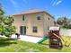 Spacious backyard features a patio, play set, a grill, and lush green grass at 238 Hunt St, Clermont, FL 34711