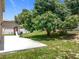 The backyard features a well-manicured lawn, lush trees, and a concrete patio, perfect for Gathering fun at 238 Hunt St, Clermont, FL 34711