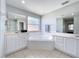Bright bathroom featuring a soaking tub and double vanity with large mirrors at 238 Hunt St, Clermont, FL 34711