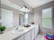 Bright bathroom featuring a dual sink vanity, framed mirror, and a window providing natural light at 238 Hunt St, Clermont, FL 34711