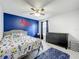 Stylish bedroom with a bright accent wall, ceiling fan, bed with colorful linens, and dresser at 238 Hunt St, Clermont, FL 34711