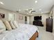 Well-lit primary bedroom featuring a queen-size bed, a TV, and a comfortable seating area at 238 Hunt St, Clermont, FL 34711