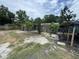 Spacious backyard with mature trees, partial fencing, and a partially covered area for outdoor enjoyment at 269 12Th Ave, Ocoee, FL 34761
