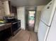 Kitchen area featuring an oven, white refrigerator, tile floor and an open doorway at 269 12Th Ave, Ocoee, FL 34761