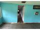 Empty living room featuring blue walls and wood flooring; an open doorway leads to other rooms at 269 12Th Ave, Ocoee, FL 34761
