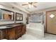 Bathroom featuring dual sinks, a soaking tub, and elegant finishes at 3310 Tall Timber Dr, Orlando, FL 32812
