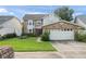Charming home with a brick facade, well-manicured lawn, and an attached two car garage at 3310 Tall Timber Dr, Orlando, FL 32812