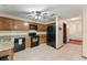 Spacious kitchen featuring tile floors, oak cabinets, and black appliances at 3310 Tall Timber Dr, Orlando, FL 32812