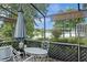 Enclosed patio with outdoor seating offers stunning views of the lake and surrounding landscaping at 3310 Tall Timber Dr, Orlando, FL 32812