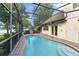 Screened-in pool area with a pool, brick paver deck, and a view of the lake at 3310 Tall Timber Dr, Orlando, FL 32812