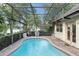 Beautiful backyard featuring a screened pool with patio furniture and landscaping at 3310 Tall Timber Dr, Orlando, FL 32812