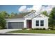 Charming single-Gathering home featuring a gray garage door, red front door and well-manicured lawn at 5277 Bowspirit Way, St Cloud, FL 34771