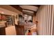Open dining area with wooden beams, a marble table, and modern appliances in the adjacent kitchen at 209 Fairway Dr # 209, Longwood, FL 32779