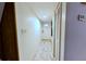 Bright hallway featuring tiled flooring, leading to a white door, offering a clean and modern aesthetic at 209 Fairway Dr # 209, Longwood, FL 32779