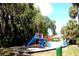Community playground area with swings, slides, climbing structures, and benches at 209 Fairway Dr # 209, Longwood, FL 32779