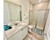 Bright bathroom features a tiled shower, wood-look flooring and a white vanity with a solid surface countertop at 3117 Caribbean Soul Dr, Kissimmee, FL 34747