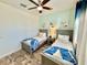 Cozy bedroom with wood-look flooring features two twin beds, a ceiling fan and cool paint tones at 3117 Caribbean Soul Dr, Kissimmee, FL 34747