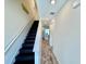 Hallway with staircase, wood floors, and view into kitchen at 3117 Caribbean Soul Dr, Kissimmee, FL 34747