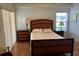 Cozy bedroom featuring a wood bed frame, bedside tables, and natural light at 4012 Capland Ave, Clermont, FL 34711