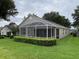 Beautiful screened-in porch with manicured landscaping at 4012 Capland Ave, Clermont, FL 34711