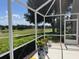 Relaxing screened-in porch with views of a golf course and lush landscaping at 4012 Capland Ave, Clermont, FL 34711
