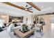 Open-concept living room flows to dining and kitchen areas, complemented by wooden beams and stylish furnishings at 5503 Banyan Bay Rd, St Cloud, FL 34771
