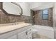Cozy bathroom featuring a tiled shower-bathtub combination, vanity, and decorative mirror at 575 Lake Mccoy Dr, Apopka, FL 32712