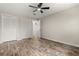 This bedroom features wood-look flooring, neutral walls, a ceiling fan, and a closet for ample storage at 575 Lake Mccoy Dr, Apopka, FL 32712