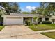 Ranch-style home with a painted brick facade, attached garage, and mature landscaping at 575 Lake Mccoy Dr, Apopka, FL 32712