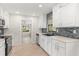Bright kitchen with white cabinets, stainless steel appliances, and a stylish blue tile backsplash at 575 Lake Mccoy Dr, Apopka, FL 32712