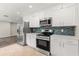 Updated kitchen features stainless steel appliances, white cabinets, and tile backsplash at 575 Lake Mccoy Dr, Apopka, FL 32712