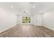 Minimalist living room with new flooring, recessed lighting, and a large window at 575 Lake Mccoy Dr, Apopka, FL 32712