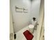 Cozy powder room with a modern toilet, tiled floors, minimalist art, and a stylish potted plant at 577 Talisi Loop, St Cloud, FL 34771
