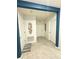 Well-lit hallway with tile flooring, decorative wall art, and neutral paint, connecting various rooms in the home at 577 Talisi Loop, St Cloud, FL 34771