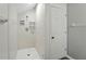 Tiled walk-in shower with shelving in a bathroom with white walls and flooring at 6839 Hidden Glade Pl, Sanford, FL 32771