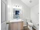 Simple bathroom with a white vanity, toilet, mirror, and light fixtures at 6839 Hidden Glade Pl, Sanford, FL 32771