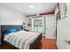 Bright bedroom with hardwood floors, sports memorabilia, a comfortable bed, and a window at 6839 Hidden Glade Pl, Sanford, FL 32771