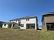 View of home's rear exterior with a well-maintained lawn, highlighting its architectural features and outdoor appeal at 4113 Sagefield Dr, Harmony, FL 34773