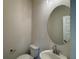 Charming half-bathroom with a modern sink and a stylish round mirror at 4113 Sagefield Dr, Harmony, FL 34773