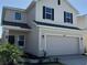 Exterior view of a two-story home with a two-car garage, modern color scheme and well-maintained landscaping at 4113 Sagefield Dr, Harmony, FL 34773