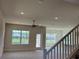 Bright, carpeted living room with a ceiling fan, large windows, and a view of the backyard and pond at 4113 Sagefield Dr, Harmony, FL 34773