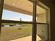 Scenic view of a pond and backyard from a large window, bringing natural light and a tranquil setting indoors at 4113 Sagefield Dr, Harmony, FL 34773