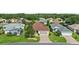 Aerial view of a home showcasing its manicured lawn, paved driveway, and mature trees at 4738 St Andrews Arc, Leesburg, FL 34748