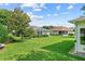 Expansive backyard featuring manicured lawn, mature trees, and view of neighboring homes at 4738 St Andrews Arc, Leesburg, FL 34748