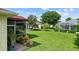 Well-maintained backyard with lush green lawn, mature trees, and screened-in lanai for outdoor enjoyment at 4738 St Andrews Arc, Leesburg, FL 34748