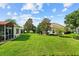 Large backyard with manicured lawn, mature trees and landscaping, perfect for outdoor activities at 4738 St Andrews Arc, Leesburg, FL 34748