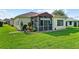 Lush backyard featuring a screened-in lanai, perfect for enjoying the outdoors at 4738 St Andrews Arc, Leesburg, FL 34748