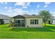 Well-maintained backyard with screened-in lanai and manicured lawn for relaxing outdoor living at 4738 St Andrews Arc, Leesburg, FL 34748